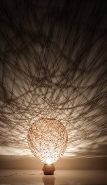 Duvarında gölgeler olan el yapımı ahşap ve halat lambası.