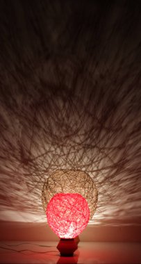 Duvarında gölgeler olan el yapımı ahşap ve halat lambası.