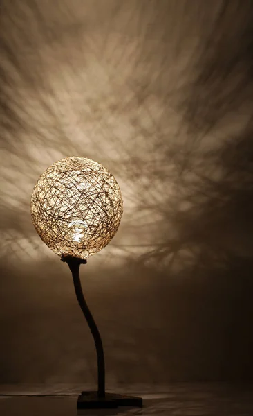 Duvarında gölgeler olan el yapımı ahşap ve halat lambası.