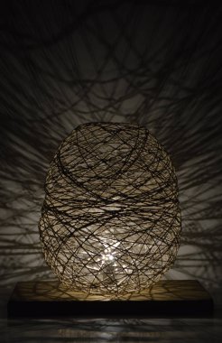 Duvarında gölgeler olan el yapımı ahşap ve halat lambası.