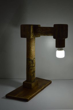 Gri arkaplanda el yapımı ham ahşap lamba