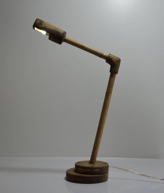 Gri arka planda el yapımı ahşap ve bambu masa lambası.