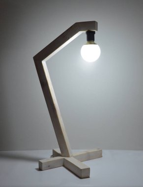 Gri arkaplanda el yapımı ahşap lamba