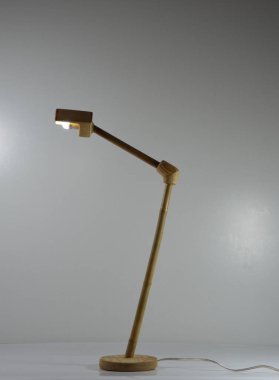 Gri arka planda el yapımı ahşap ve bambu masa lambası.