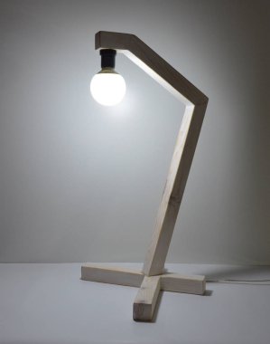 Gri arkaplanda el yapımı ahşap lamba