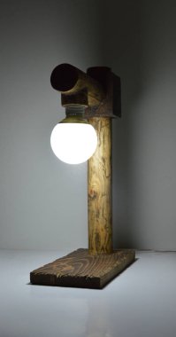 Gri arkaplanda el yapımı ahşap lamba 