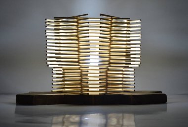 El yapımı ahşap lamba, koyu gri arka planda bambu çubukları var.