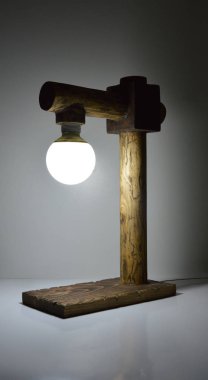 Gri arkaplanda el yapımı ahşap lamba 