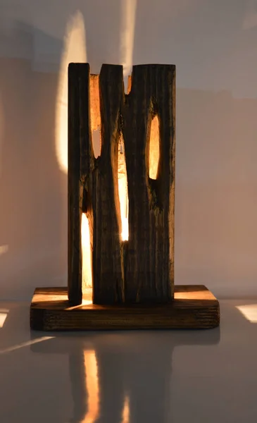 Handmade raw wood lamp on gray background