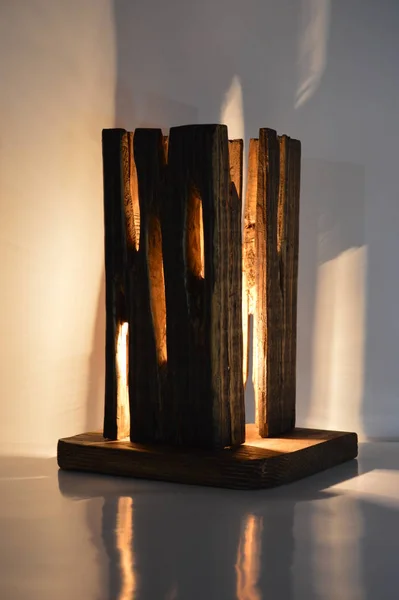 Handmade raw wood lamp on gray background