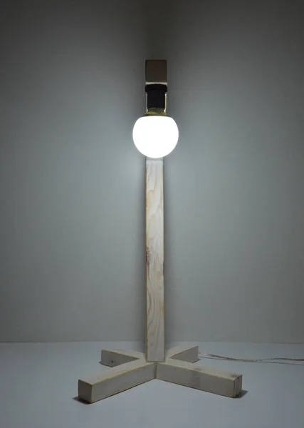 Handmade wooden lamp on gray background