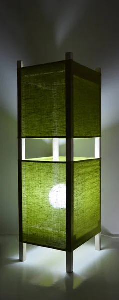 濃い灰色の背景に緑のリネンシェードと手作りの木製のランプ — ストック写真
