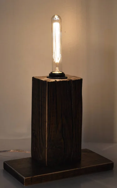 Handmade wooden lamp on gray background