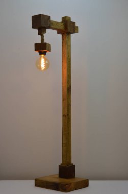 Gri arkaplanda el yapımı ahşap lamba