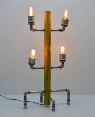 Gri arkaplanda el yapımı ahşap ve metal lamba