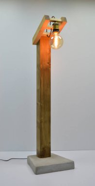 Gri arkaplanda el yapımı ahşap ve beton zemin lambası