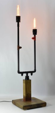 Ahşap, metal borular ve teçhizatlı el yapımı lamba.