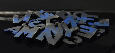 Kara ışıklı arka plan merkezine boyanmış el yapımı ahşap harfler.