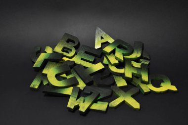 Kara ışıklı arka plan merkezine boyanmış el yapımı ahşap harfler.