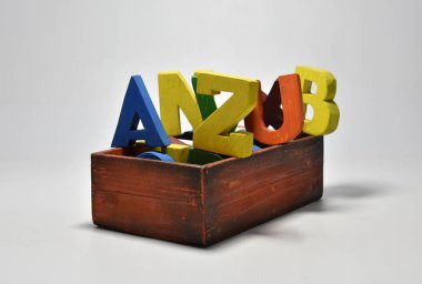 Kara ışıklı arka plan merkezine boyanmış el yapımı ahşap harfler.