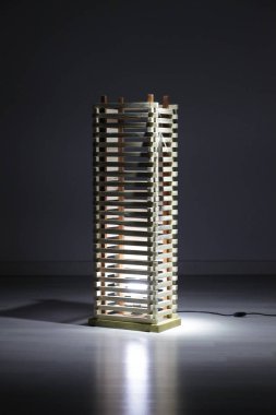 Koyu arkaplanda ahşap lamba var.