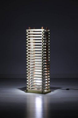 Koyu arkaplanda ahşap lamba var.