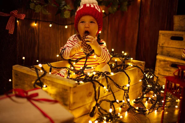 Enfant avec des cônes dans les lumières de Noël — Photo