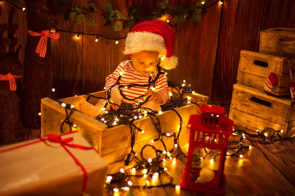Ребенок сидит с рождественскими огнями — стоковое фото