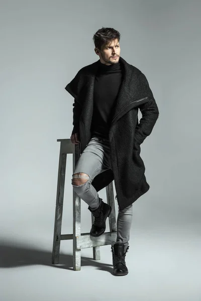 Handsome model in black long coat — Stock Photo, Image