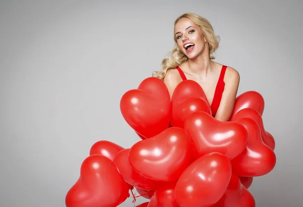 Blond woman holding  heart balloons — Stock Photo, Image