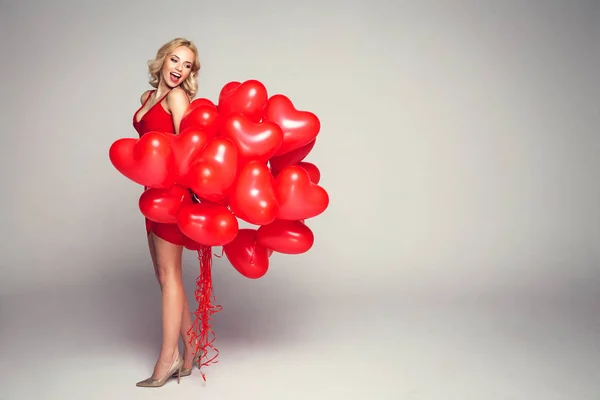 Блондинка с воздушными шарами сердца — стоковое фото