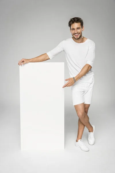 Smiling handsome man showing white empty space — Stock Photo, Image