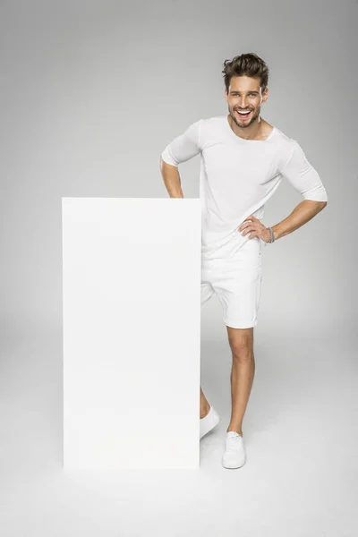 Sonriente hombre guapo mostrando el espacio vacío blanco — Foto de Stock