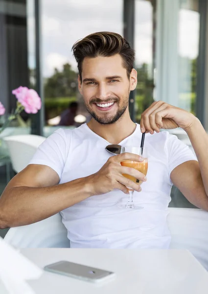 Przystojny mężczyzna pije sok ornage — Zdjęcie stockowe