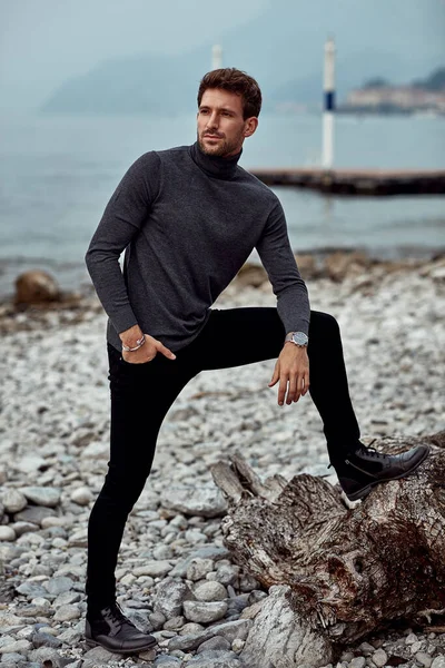 Modelo masculino elegante posando ao ar livre sobre fundo do lago — Fotografia de Stock