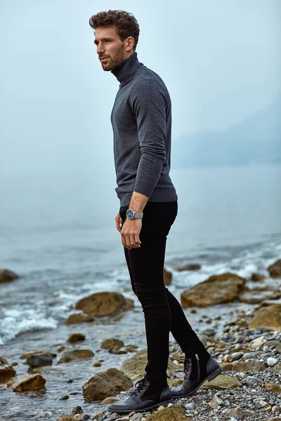 Handsome man in autumn outfit relaxing on the beach — Stok fotoğraf