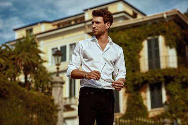 Handsome young man in front of luxury home villa