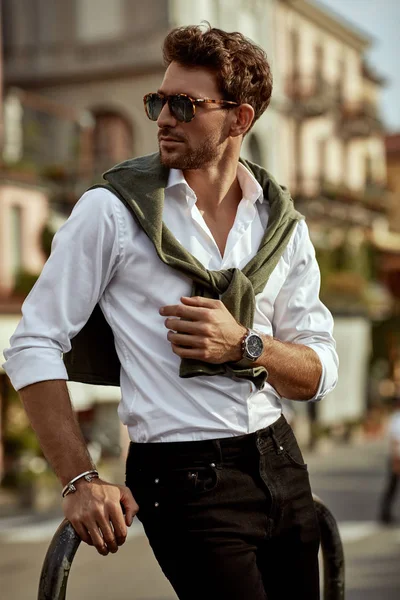 Stylish man wearing sunglasses and white shirt with tied sweater — ストック写真