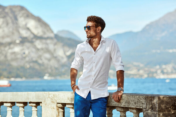 Portrait of handsome man wearing elegant white shirt and sunglas