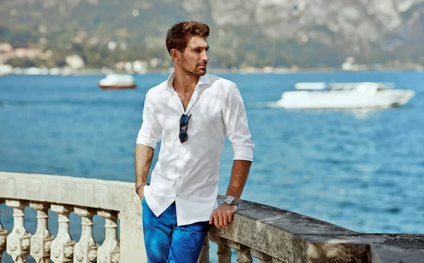 Bello giovane uomo che indossa elegante camicia bianca e posa outdoo — Foto Stock