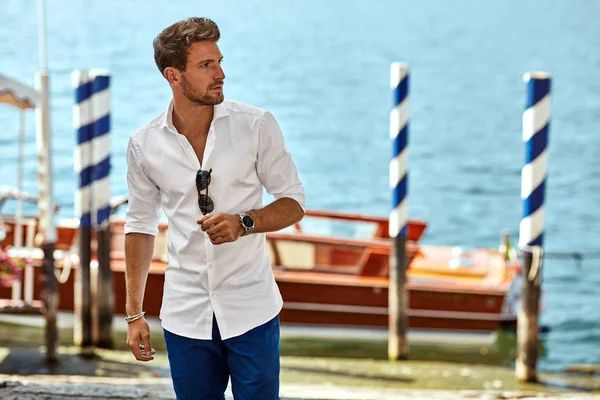 Guapo joven vestido con elegante camisa blanca y de pie cerca —  Fotos de Stock