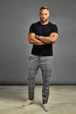 Handsome man posing with watch and looking at camera, isolated o