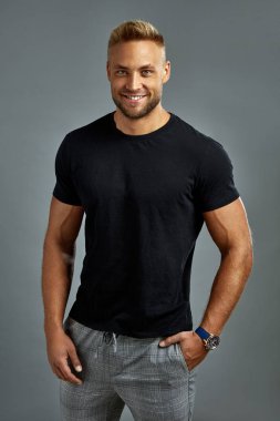 Sexy man in balck t-shirt looking at camera and smiling