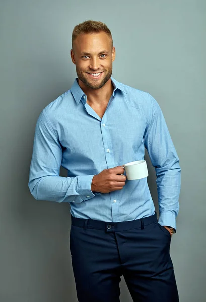 Handsome smiling man with a white cup — 图库照片