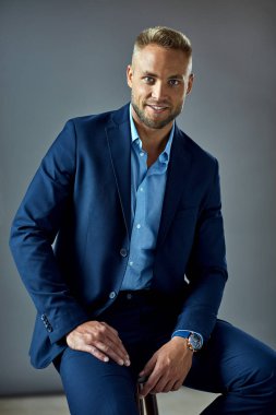 Handsome young man in blue suit looking at camera 