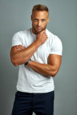 Handsome man touching his beard isolated on gray background 