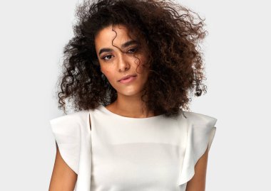Cute young latin woman with afro hairstyle isolated on white bac