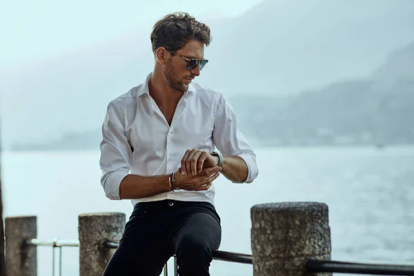 Stylish man in white shirt checking the time over the mountains — Stock Photo, Image