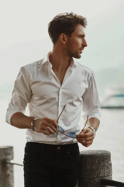 Profile portrait of stylish man wearing white shirt and holding — Stock Photo, Image