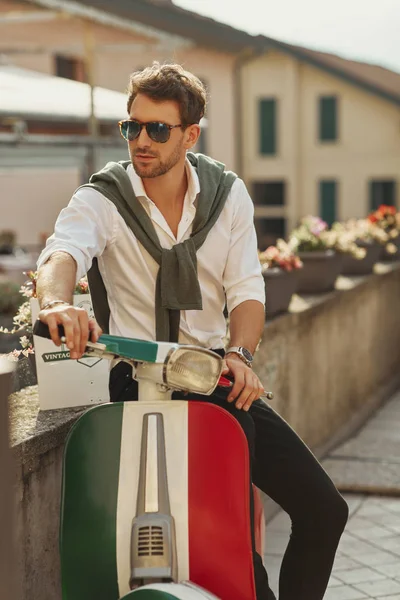 Stijlvolle Italiaanse man in wit shirt met gebonden trui op bac — Stockfoto